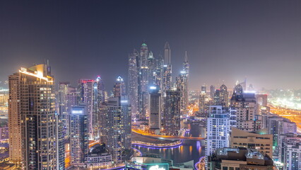 View of various skyscrapers in tallest recidential block in Dubai Marina aerial all night timelapse