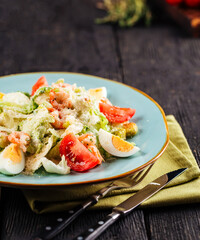 Closeup on fresh caesar salad with shrimp sprinkled with parmesan