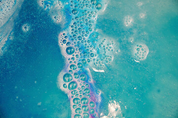 Bright colorful bath foam from the water bomb. Blue and pink bubbles and waves and spray