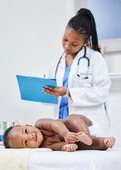 Shes a perfectly healthy baby. Shot of a doctor making notes about her infant patient on a clipboard.