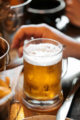 Glass mug of fresh cool beer on dinner table