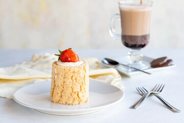 Strawberry log cake on a white background. With hot chocolate on the side. close up