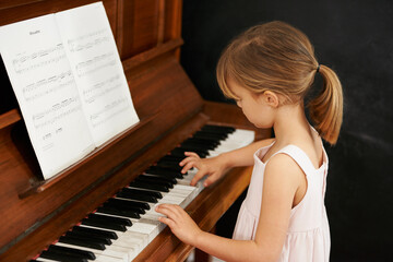 Practising for the recital. Cropped shot of a little girl playing the piano.