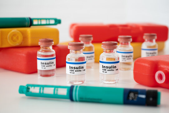 Insulin ampoules and insulin syringe with cold packs against a white background: properly cooling and storing insulin. 