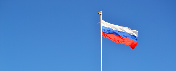 banner, The flag of Russia is flying in the wind against the blue sky