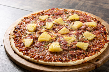 Hawaiian pizza with pineapple,ham and cheese on wooden table 