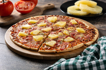 Hawaiian pizza with pineapple,ham and cheese on wooden table 