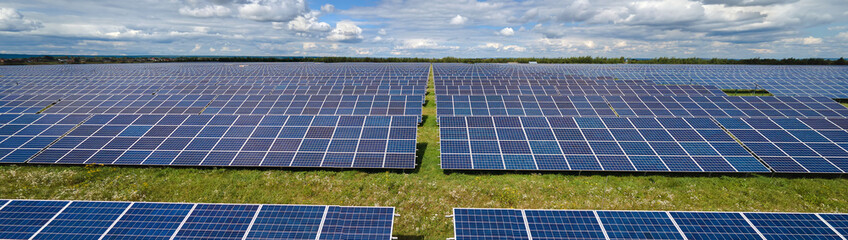 Aerial view of large sustainable electrical power plant with rows of solar photovoltaic panels for...