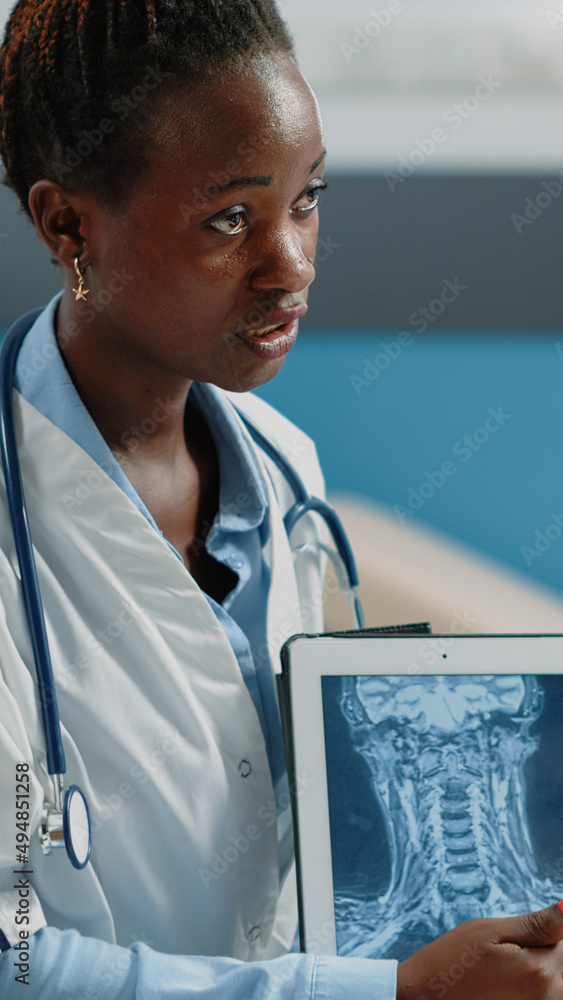 Aufkleber close up of medic pointing at tablet display with radiography, analyzing bones structure and healthc