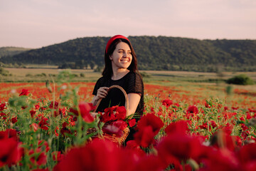 woman in black dress on sunset at the poppies flowers field