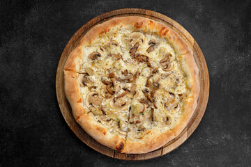 Pizza with mushrooms and chicken on a dark background