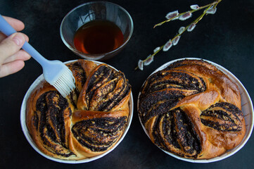 Yeast braid with poppy seeds on a dark background.