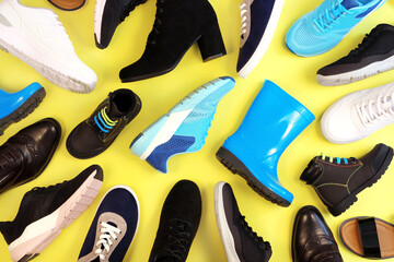 Many different pairs of shoes for different seasons.
a lot of shoes on yellow background, top view. 