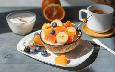 Fruit salad in coco, yogurt, caffe. Concepr of a healthy breakfast