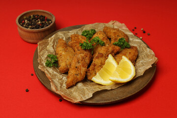 Concept of tasty food with Chicken strips on red background
