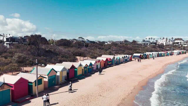BRIGHTON BEACH, AUSTRALIA - SEPTEMBER 2018: Colourful beach huts with tourists