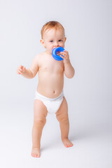 cute baby girl in a diaper stands in full height isolated on a white background