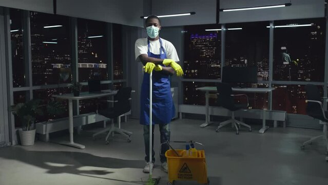 Full-length View Of African-American Janitor In Safety Mask Look At Camera Standing In Office