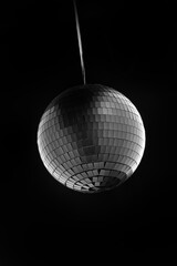 Vertical shot of hanging disco ball isolated on black background