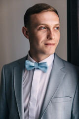 Happy groom on the wedding day. Preparing the groom before the ceremony at home.