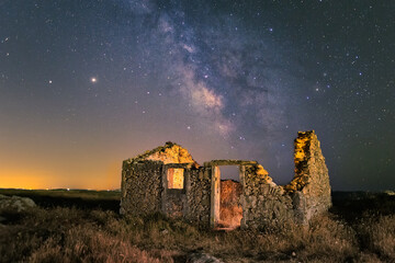 Old abandoned broken ancient building in the background of a starry sky.