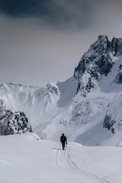 Photo of man walking in snaw against of mountain