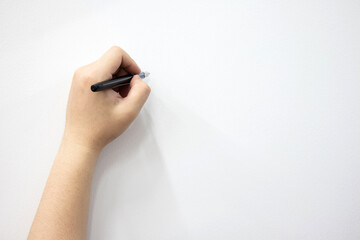Man's hand holding a pen writing on a white background. with space to design for you