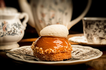 Closeup of caramel nuts cake with creamy topping on a plate