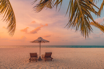 Sunset beach. Beautiful tropical island shore, two sun beds lounger, parasol under palm tree. Sand sea horizon, colorful dream sky, calm relax. Summer vacation beach landscape. Romantic couple resort 