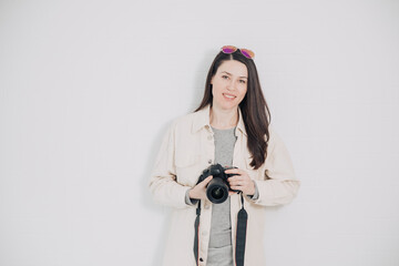 Photographer holds a camera in his hands and smiles. Working as a photographer. Cheerfulness and...