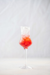 Strawberry liqueur with ice in a glass.