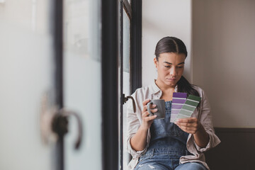 Mid adult female choosing wall paint colours