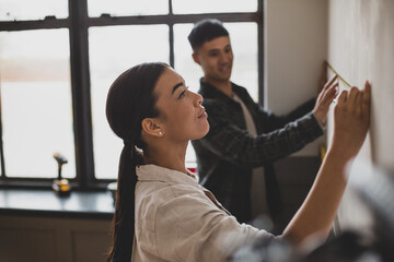 Mid adult couple measuring wall for home renovations