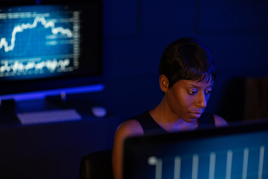 Female stockbroker working late at night trading