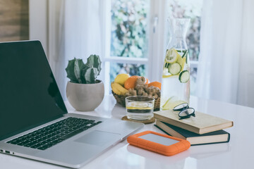 Morning time at home healthy breakfast laptop and drink on table..Natural meal and fruits at work in remote office health nutrition food with computer freelance desktop workspace. Home working concept