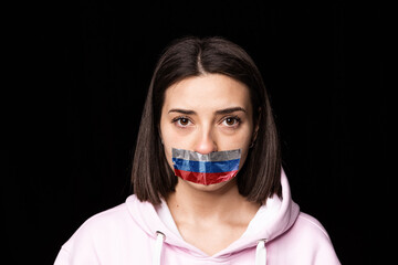 Front camera view. Portrait of young upset girl with three colors duct tape over her mouth isolated...