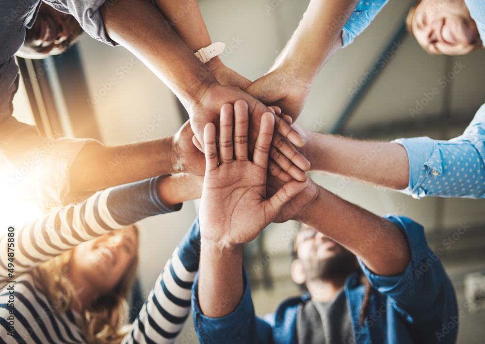 Poster this is how it gets done. shot of a group of creative businesspeople standing with their hands in a 