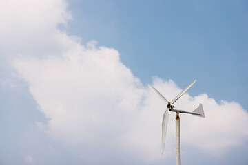 old wind turbine with blue sky and white cloud. energy conservation concept.