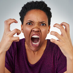 Im so annoyed with you right now. Portrait of an angry young woman screaming against a grey background.