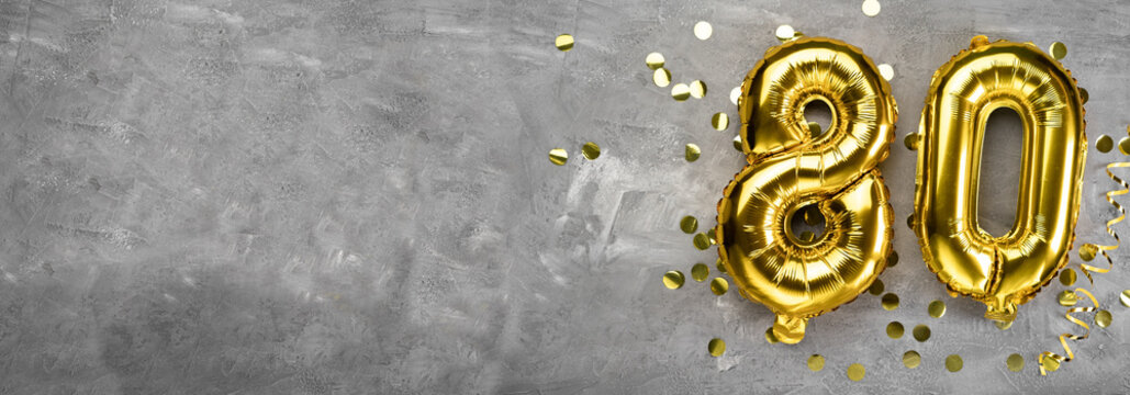 Yellow foil balloon number, number eighty on a concrete background. Greeting card with the inscription 80. Anniversary concept. for anniversary, birthday, new year celebration. banner,