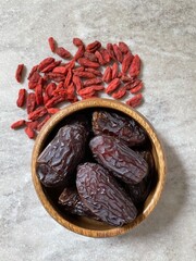 Goji berries and dates in wooden bowl