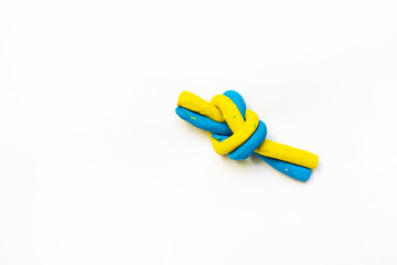 blue-yellow knot with plasticine as a symbol of invincible Ukraine on a white background, War in...