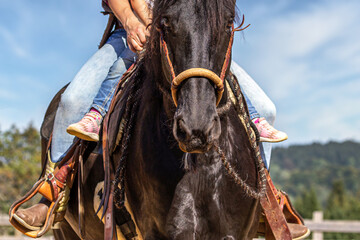 Riding mom: A mother rides a horse with her child. Riding with kids.
