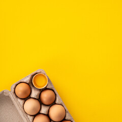 Fresh brown chicken eggs isolated on yellow table background.