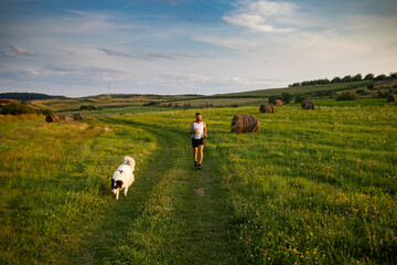 Fototapeta premium man running with his dog at sunset healthy active lifestyle