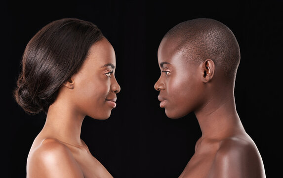 Perfect profiles. Two beautiful african women standing face to face against a black background.