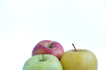 Close-up view of red, yellow and green apples on a white background.