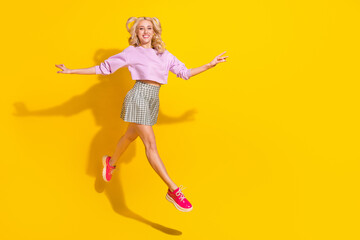 Full body photo of excited sportive girl run arms wings fly beaming smile isolated on yellow color background