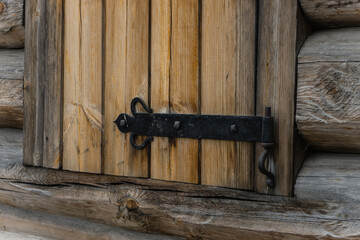 the forged hinge on the wooden shutter close up. ancient Russian architecture