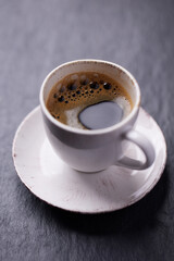 Cup of coffee on dark stone background. Close up.